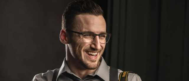 Man smiling against a black background